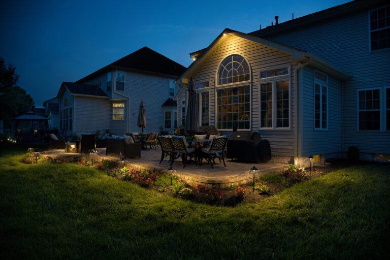 Beautifully lit backyard patio with LED landscape lighting at dusk